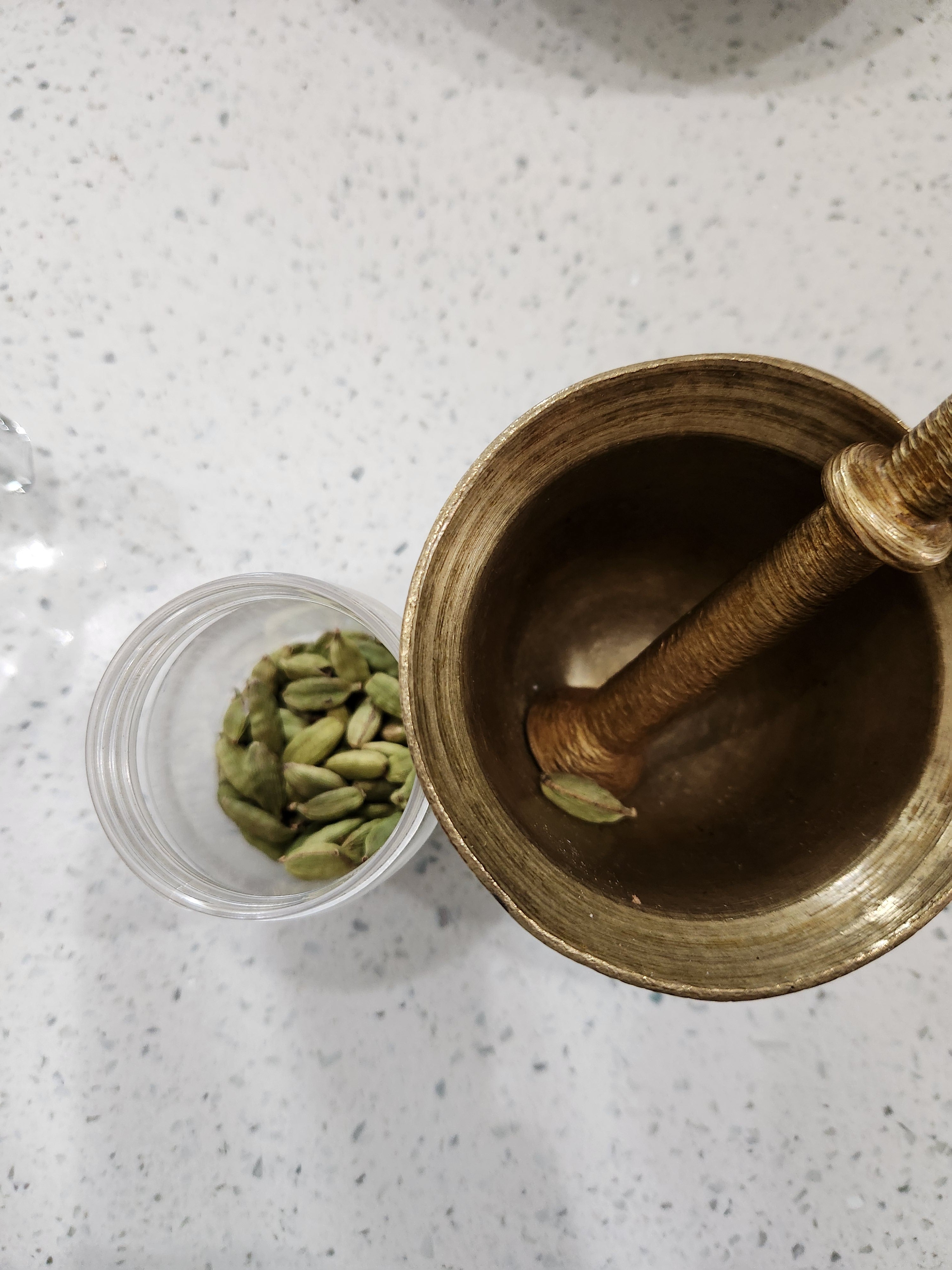 An image of a bottle of cardamom and mortar and pestle